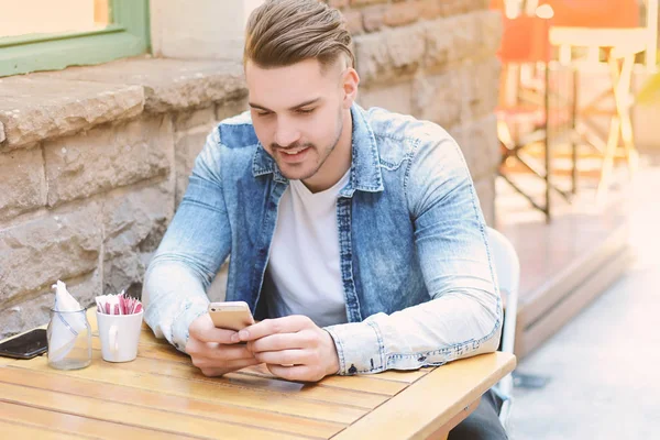 Young man in coffee shop talking on the phone