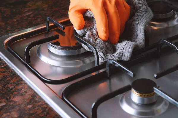 Close up view of hands in rubber gloves cleaning hob — Stock Photo, Image