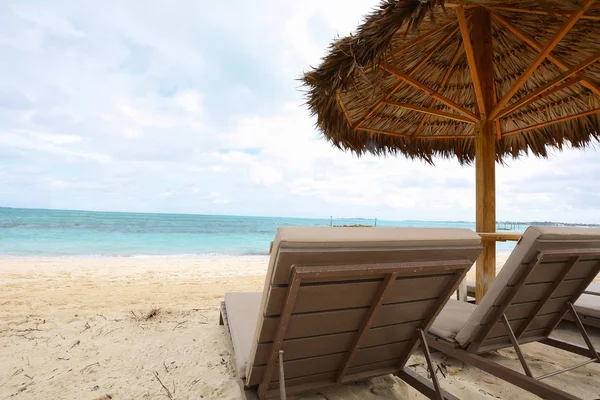 Spiaggia di sabbia con ombrellone e lettini . — Foto Stock