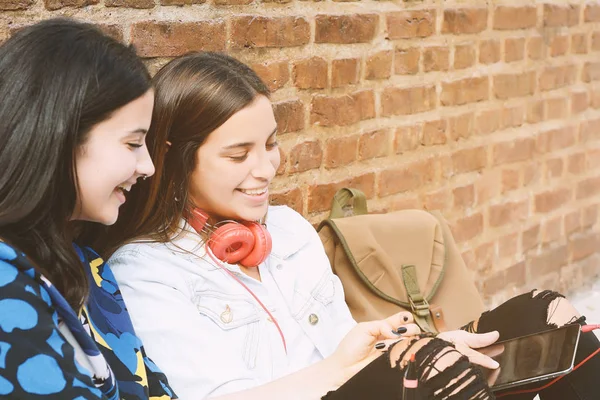 Primer plano. Dos jóvenes hermosas amigas usando tableta digital —  Fotos de Stock