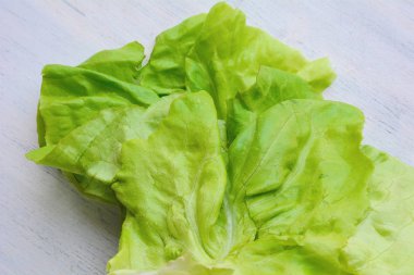 Beyaz ahşap zemin üzerinde taze marul.