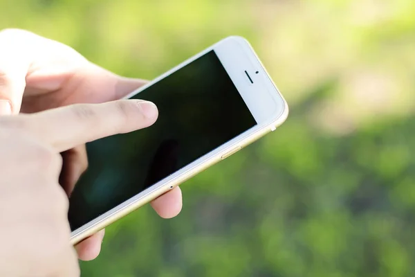 Las manos de las mujeres jóvenes sosteniendo smartphone . — Foto de Stock