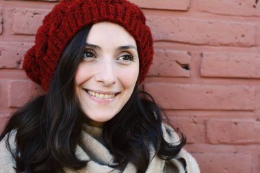 Kadın kış portre bir tuğla duvara.