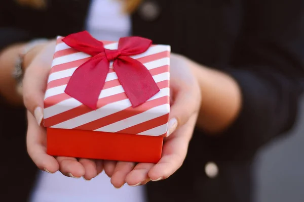 Manos femeninas sosteniendo una caja de regalo, regalo . — Foto de Stock