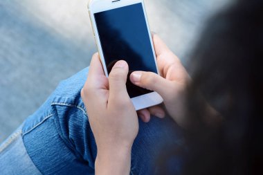 Akıllı telefon tutan kadın elleri.