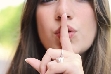 Mutlu genç kadın sessiz bir jest yapma