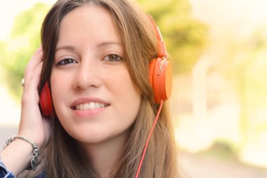 Kulaklıklar bir park olan latin kadın.