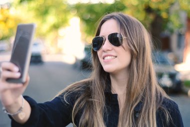 Genç kadın selfie onun smartphone ile alarak.