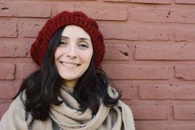 Kadın kış portre bir tuğla duvara.