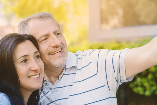 Middle-aged couple taking selfie with a smartphone — Stock Photo, Image