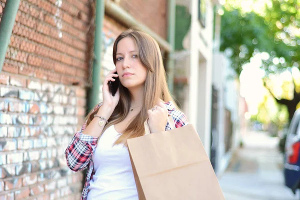 젊은 여성 스마트폰을 사용 하 여 쇼핑백을 — 스톡 사진