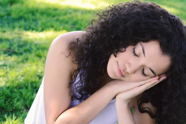 Parkta üzerinde uyuyan genç latin kadın. — Stok fotoğraf