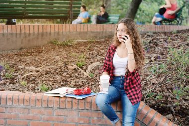 Genç öğrenci kız cep telefonunuzda konuşuyor.