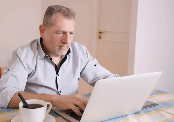 Zakenman die werken met de laptop op zijn huis — Stockfoto