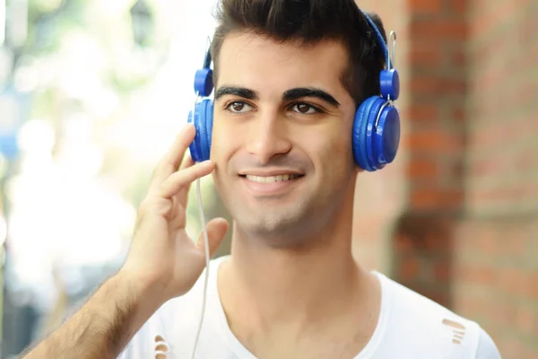 Uomo latino ascoltare musica con le cuffie . — Foto Stock