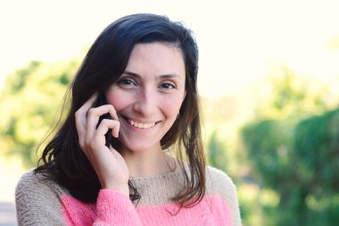 Genç bir kadın cep telefonuyla konuşuyor..