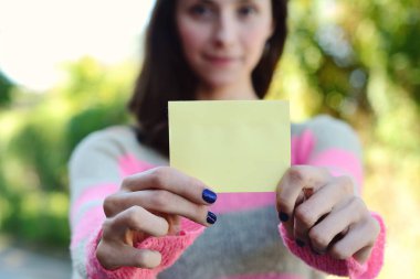 Boş bir not defteri açık havada gösterilen kadın.