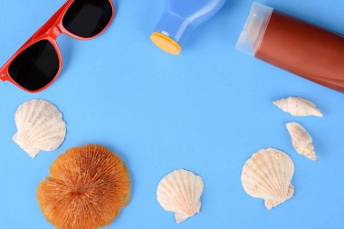 Güneş gözlüğü, kabukları, deniz yıldızı, güneş kremi ve şapka Üstten Görünüm