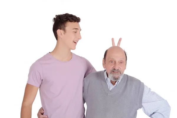 Nieto bromeando a su abuelo con orejas de conejo —  Fotos de Stock
