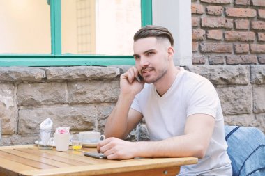 Telefonda konuşurken kafede genç adam