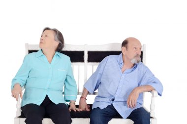 Birbirimizi görmezden ve arka arkaya koltukta oturan rahatsız eldery bir çift. Tartışıyor. İzole beyaz arka plan