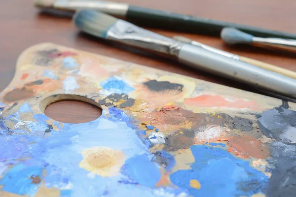 カラフルなオイル ペイント ストロークと木製の背景のペイント ブラシ アーティストのパレットです アート コンセプト — ストック写真