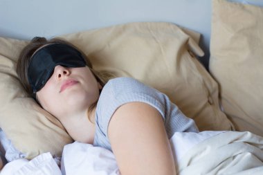 Genç kadın yatakta uyuyor.