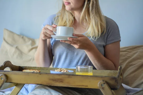 Молодая женщина завтракает в постели — стоковое фото