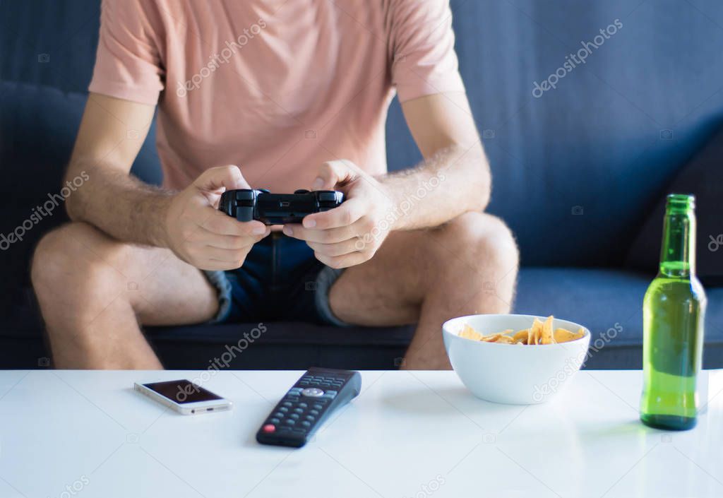 Young man playing video games at home.