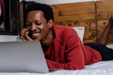 Yatakta onun laptop kullanan genç adam