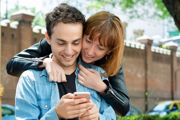 在智能手机上使用应用程序的年轻夫妇 — 图库照片