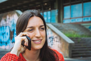 Genç bir kadın cep telefonuyla konuşuyor..