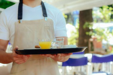 Genç garson holding tepsi.