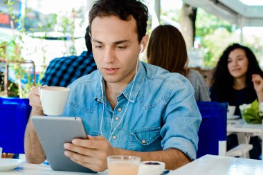 Kafede tablet ile genç adam.