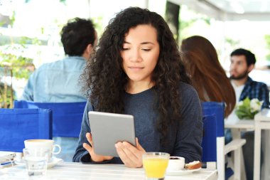 Kahve dükkanında tabletli genç bir kadın..