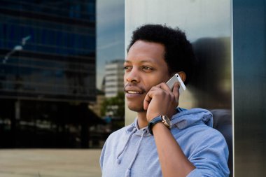 Cep telefonu dışında konuşan genç latin adam.