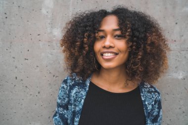 Gri duvara karşı Afro-Amerikalı kadın.