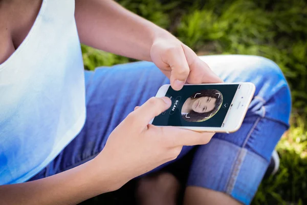 Woman unlocking smartphone with facial recognition technology