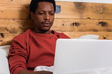 Yatakta onun laptop kullanan genç adam