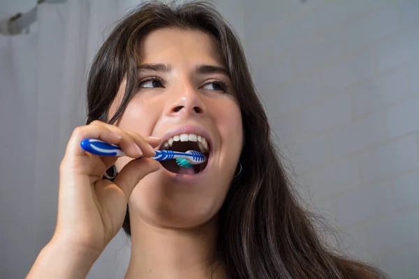 年轻女子与牙刷刷牙 — 图库照片