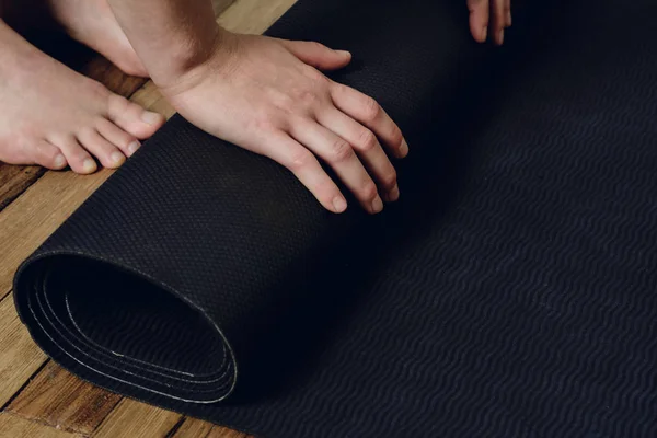 Close-up of young woman rolling her fitness mat — Stock Photo, Image
