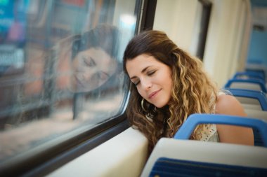 Bir tren seyahat pencerenin yanında uyuyan kentsel kadın.