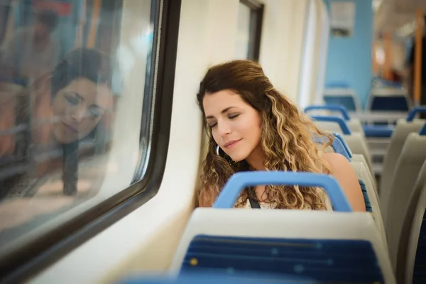Městská žena spí v cestování vlakem vedle okna. — Stock fotografie