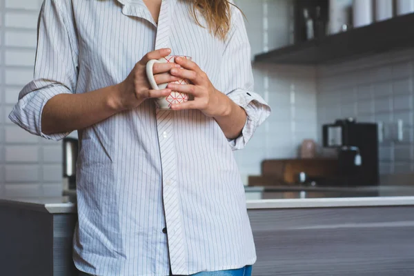 Молодая женщина пьет кофе дома — стоковое фото