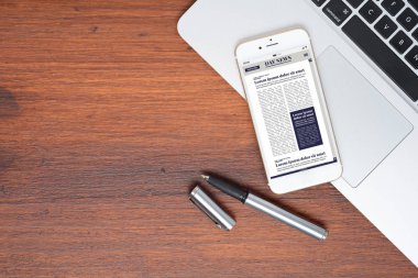 Ofis masası ve akıllı telefondan son dakika haberleri.