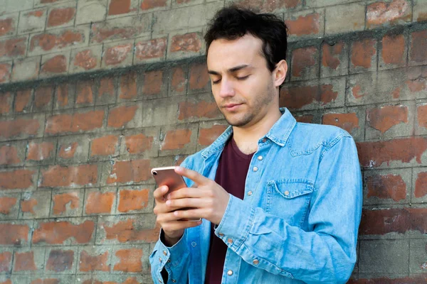 Young man typing on his phone. — Stock Photo, Image