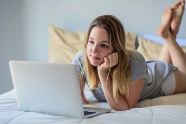 Genç kadın yatakta onu laptop kullanma