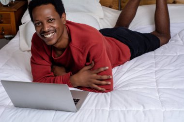 Yatakta onun laptop kullanan genç adam