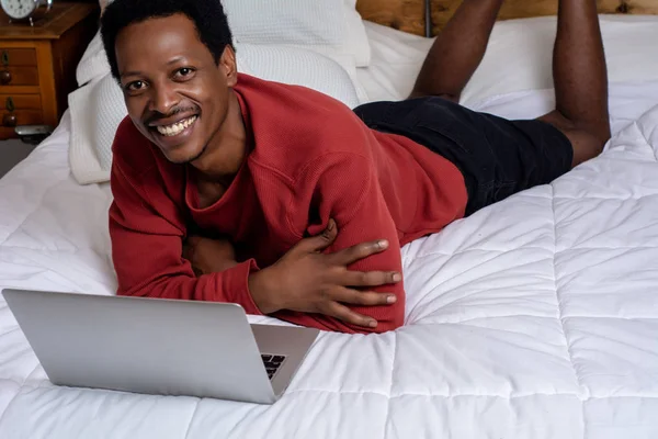 Yatakta onun laptop kullanan genç adam