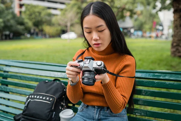 Asiatische Frau benutzt eine professionelle Kamera. — Stockfoto